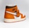 A stylish athletic shoe with a high-top design, featuring a combination of orange, brown, and white colors. The shoe displays a prominent logo on the side and a tag attached to the laces.